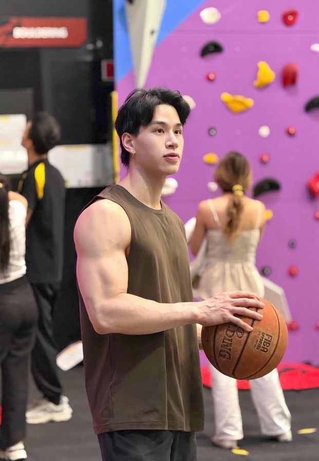 เทรนเนอร์เท็น ในชุดเสื้อกล้ามออกกำลังกายถือลูกบาสเกตบอลอวดกล้ามแขนสุดล่ำ